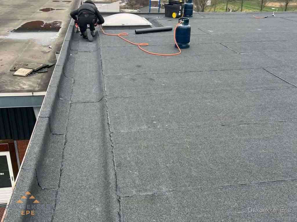 Dakdekker repareert bitumen dakbedekking op groot plat dak in Epe Dakdekker repareert bitumen dakbedekking op groot plat dak in Epe