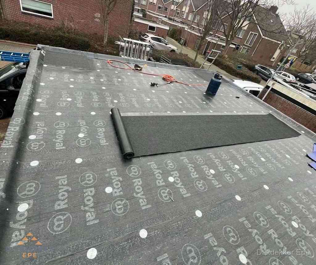 Dakdekker aan het werk met gasbrander op plat bitumen dak in Epe Dakdekker aan het werk met gasbrander op plat bitumen dak in Epe